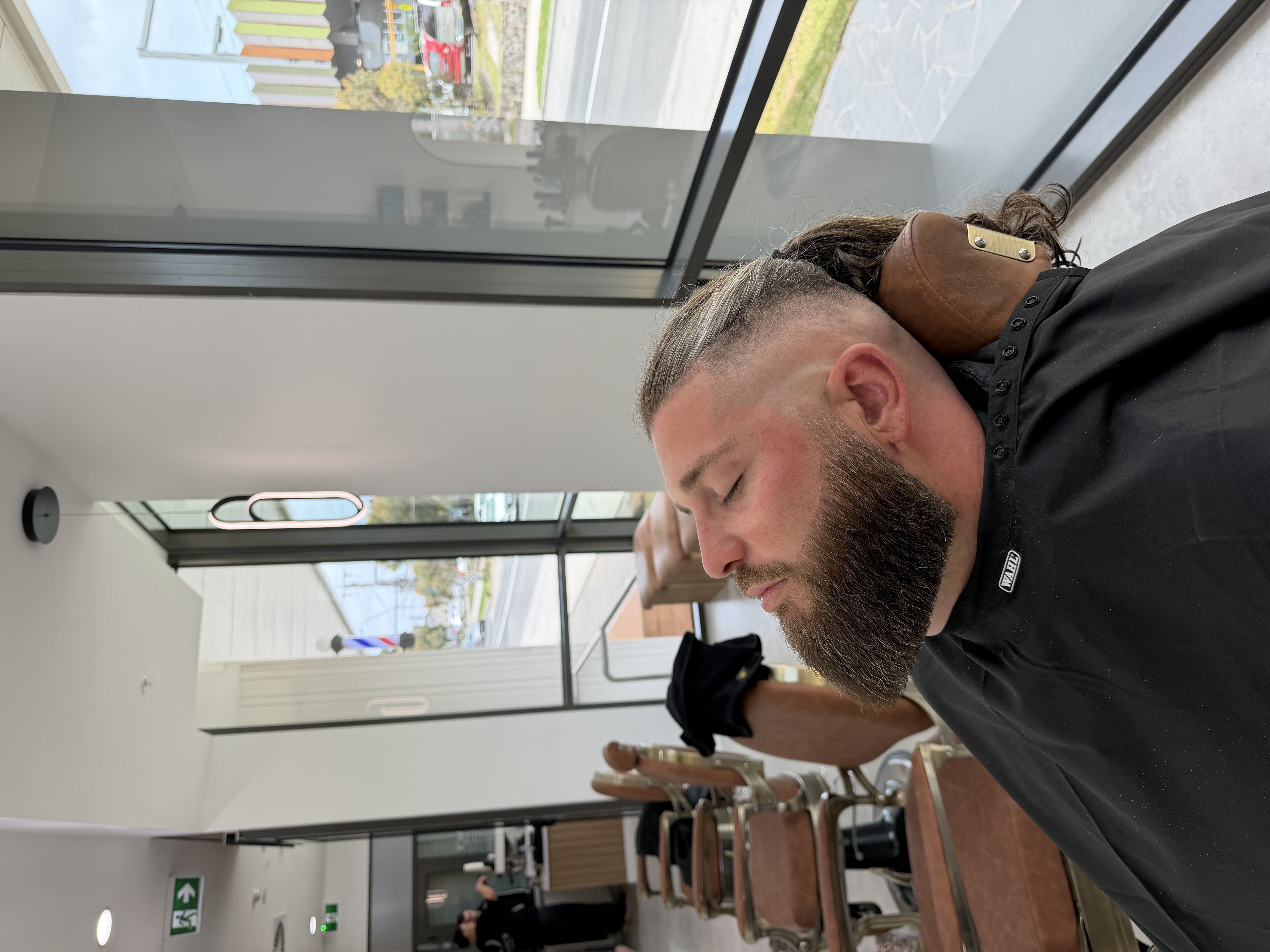 Full beard shaped with a sharp cheek line and clean fade